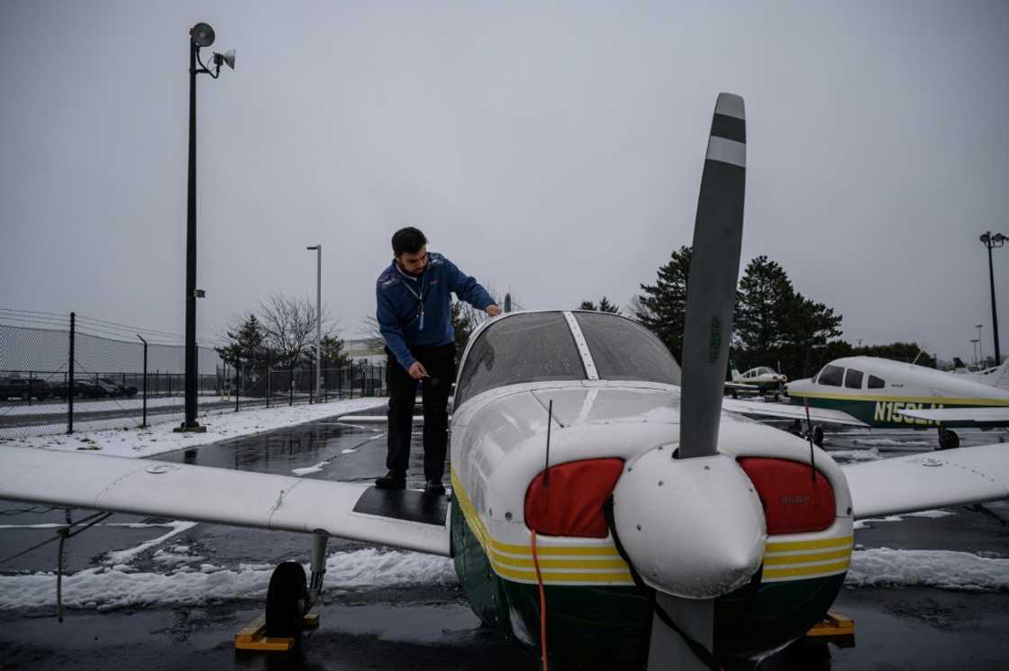 An instructor stands before training aircraft at the Farmingdale State College flying school in Farmingdale, New York An instructor stands before training aircraft at the Farmingdale State College flying school in Farmingdale, New York