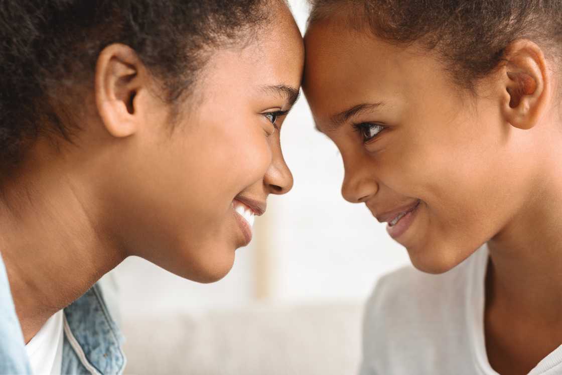 Two sisters looking at each other with love Two sisters looking at each other with love