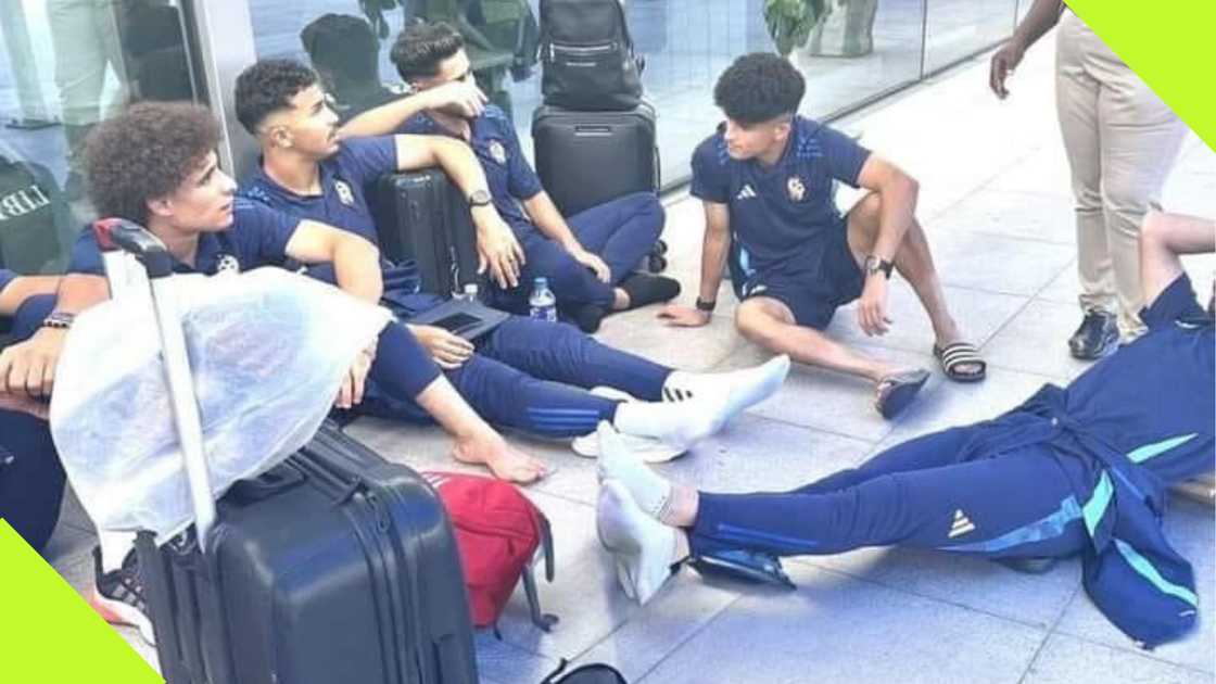 Libyan players sitting on the floor at an airport in Nigeria.