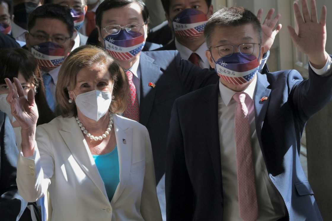 Visiting US House Speaker Nancy Pelosi and Taiwanese Parliament Vice Speaker Tsai Chi-chang wave to journalists during her arrival at the Parliament in Taipei on August 3, 2022