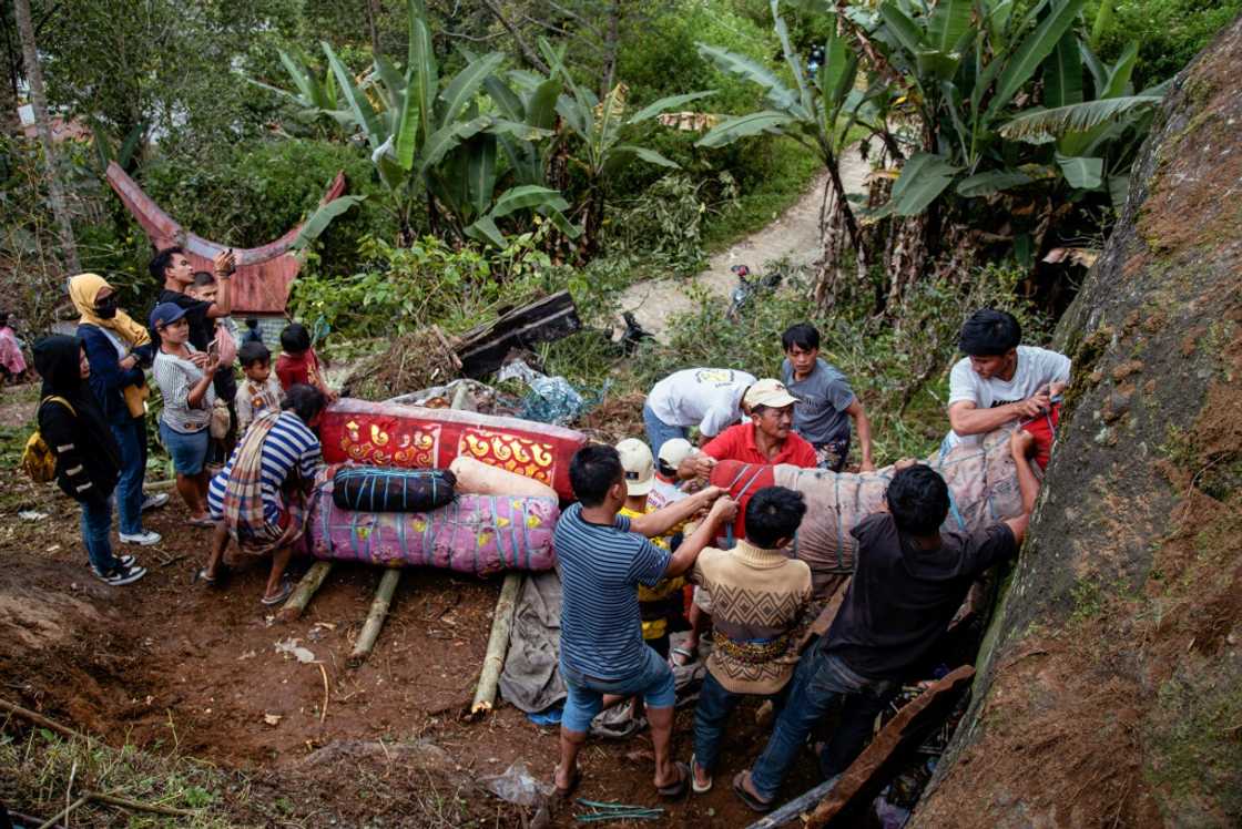 Coffins holding the preserved bodies of Indonesians' loved ones are pulled from a burial cave carved into the mountainside Coffins holding the preserved bodies of Indonesians' loved ones are pulled from a burial cave carved into the mountainside