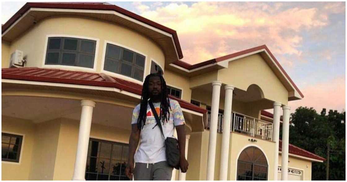 Famous Ghanaian celebrity, Samini, stands in front of his house.