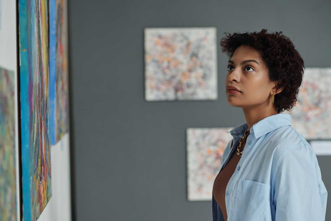 A woman looks at a photo on the wall