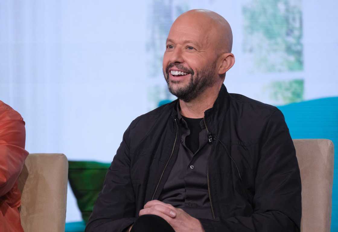 Jon Cryer in a black shirt and jacket during an interview