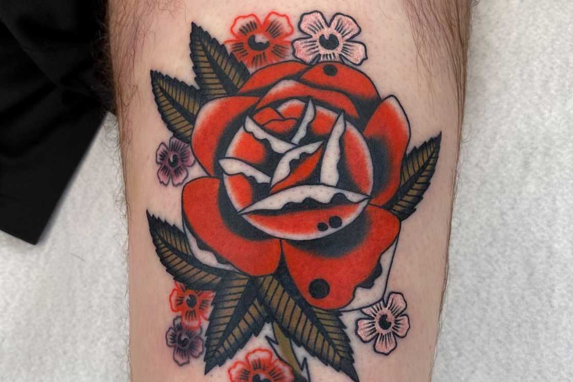 A striking old school rose leg tattoo A striking old school rose leg tattoo