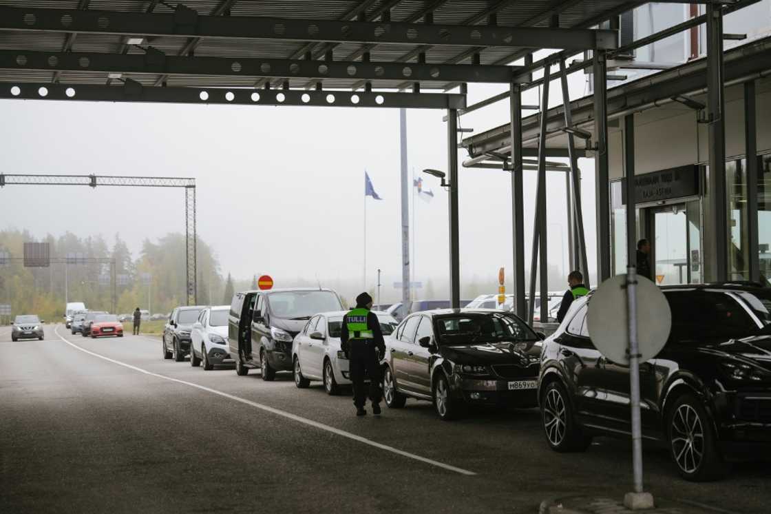 Dozens of cars and buses with Russian licence plates are lined up at the border Dozens of cars and buses with Russian licence plates are lined up at the border