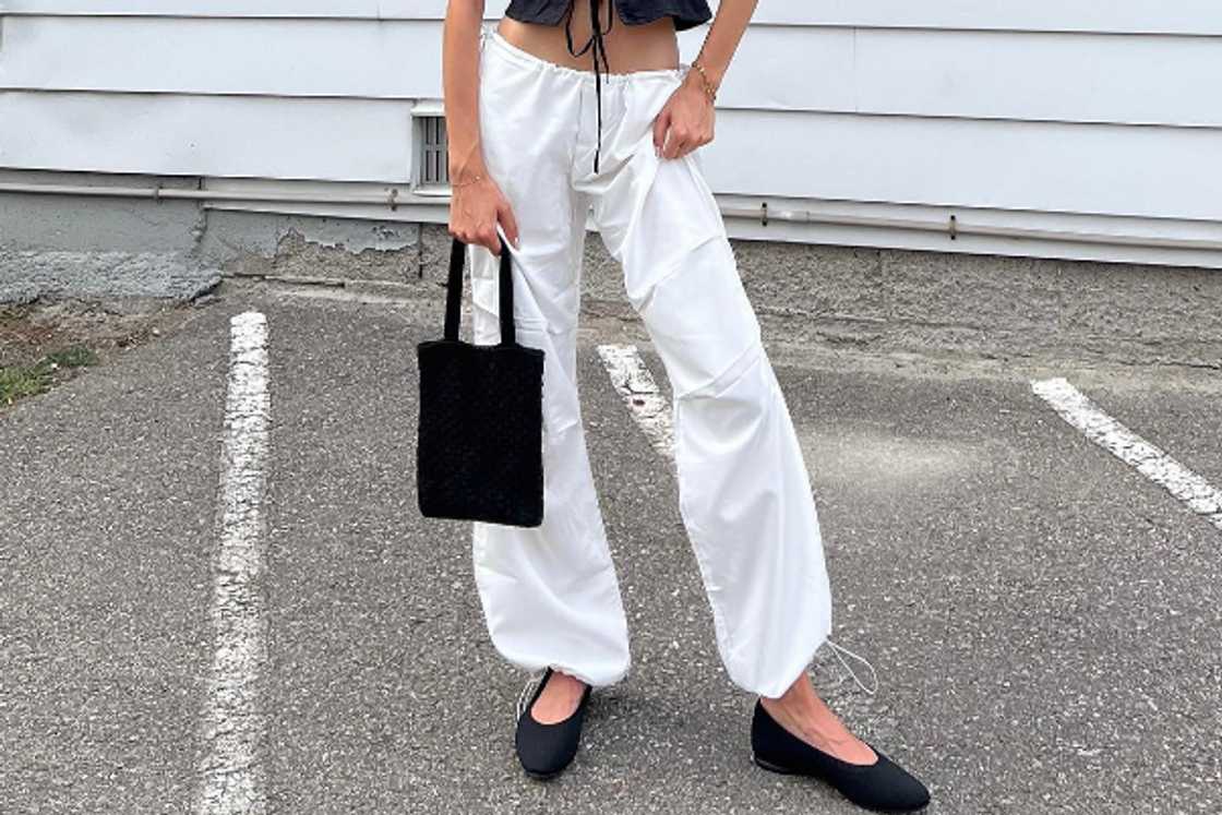 A woman wearing a pair of black ballet flat shoes