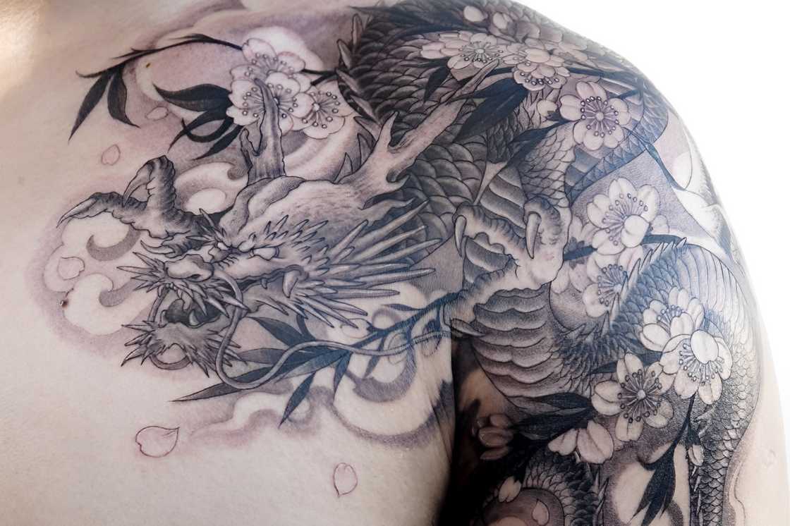 A man with a cherry blossom dragon tattoo on the upper arm A man with a cherry blossom dragon tattoo on the upper arm
