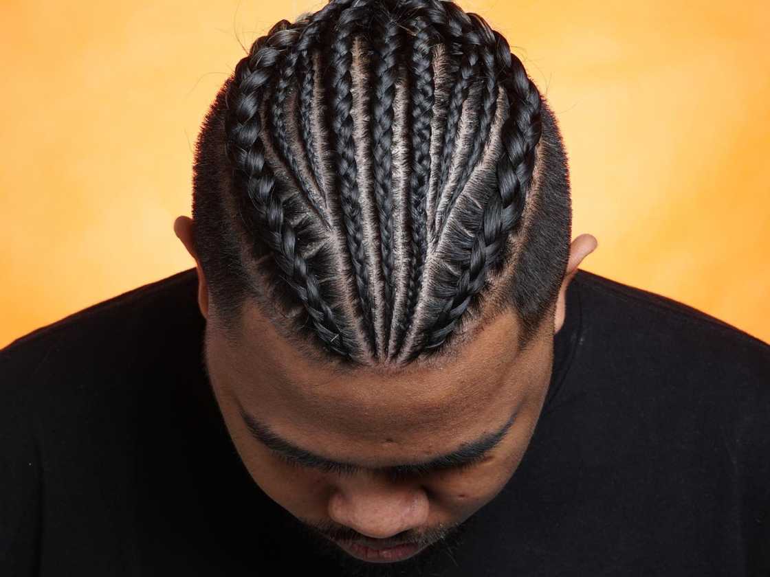 A round-faced man with braided undercut