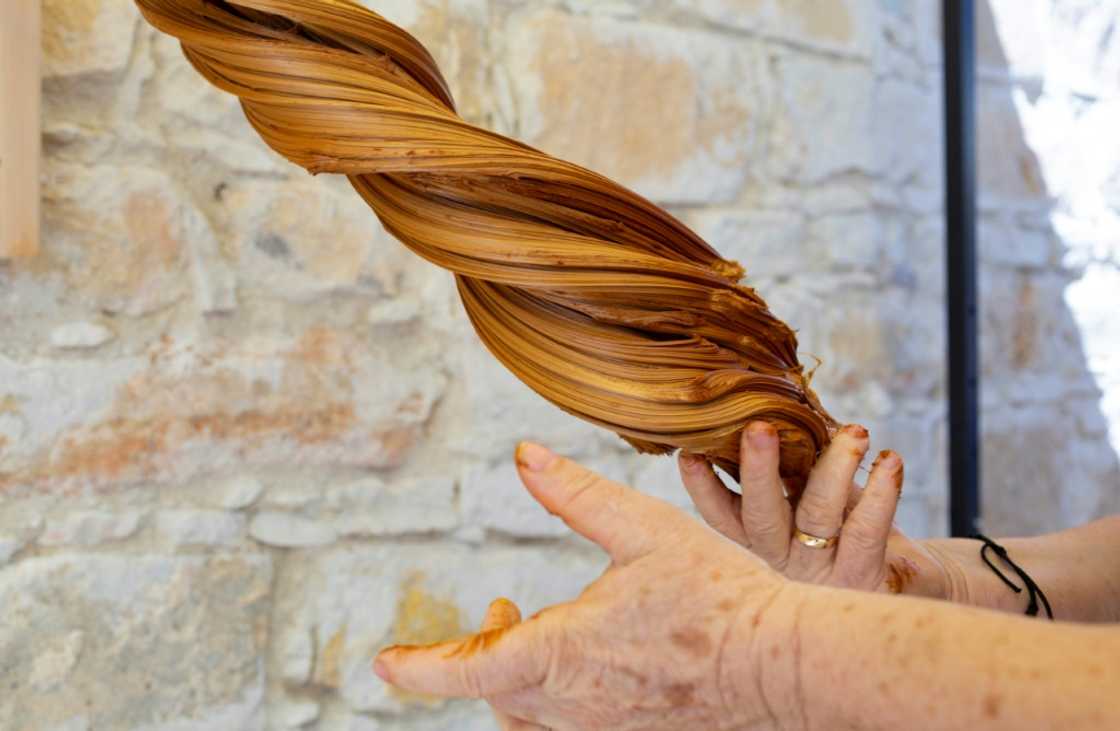 A woman demonstrates how to make pasteli, a kind of carob toffee