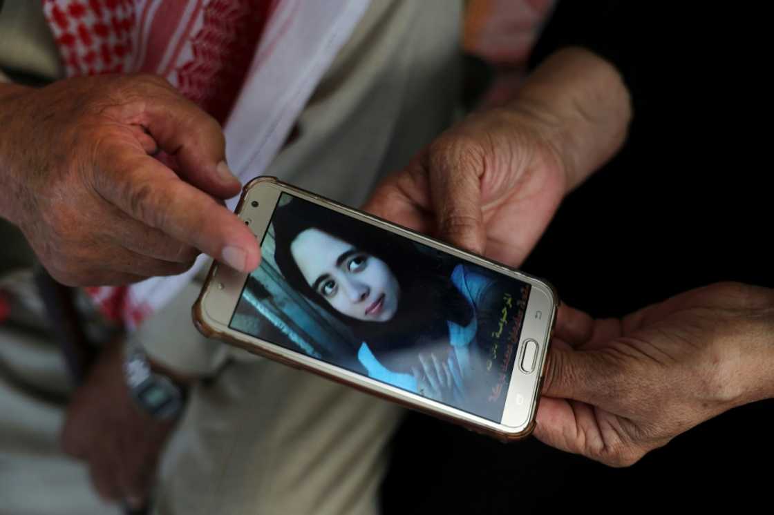 Palestinians Suleiman and Nazmiya Baraka display a picture of their daughter Istabraq, who was killed by her husband last year in the Gaza Strip