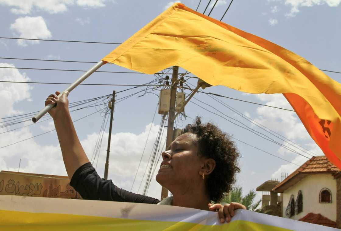 A Sudanese woman raises a flag during a pro-democracy rally in the capital Khartoum A Sudanese woman raises a flag during a pro-democracy rally in the capital Khartoum