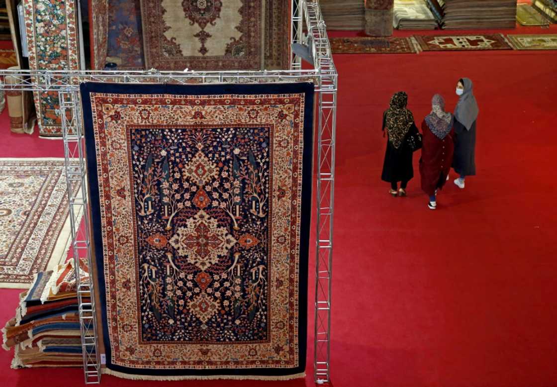 Visitors pass a traditional Iranian carpet design at the 29th Handmade Carpet Exhibition in Tehran Visitors pass a traditional Iranian carpet design at the 29th Handmade Carpet Exhibition in Tehran