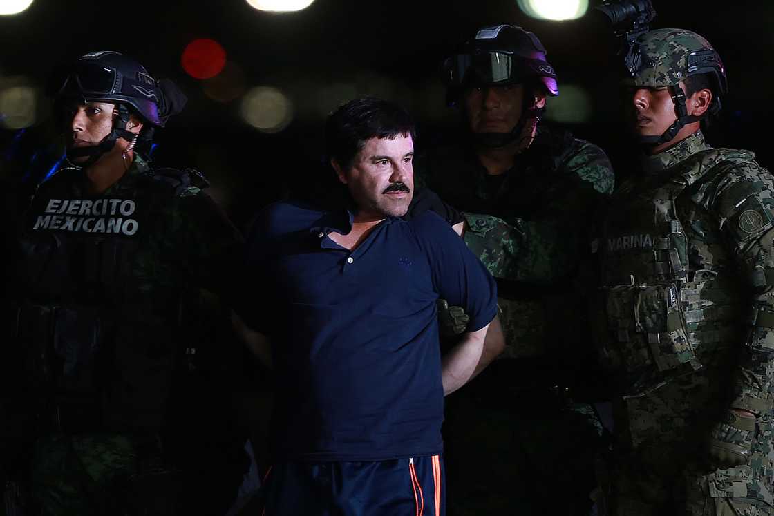 Joaquin Guzman (centre) is escorted by Mexican security forces at a Navy hangar in Mexico City Joaquin Guzman (centre) is escorted by Mexican security forces at a Navy hangar in Mexico City
