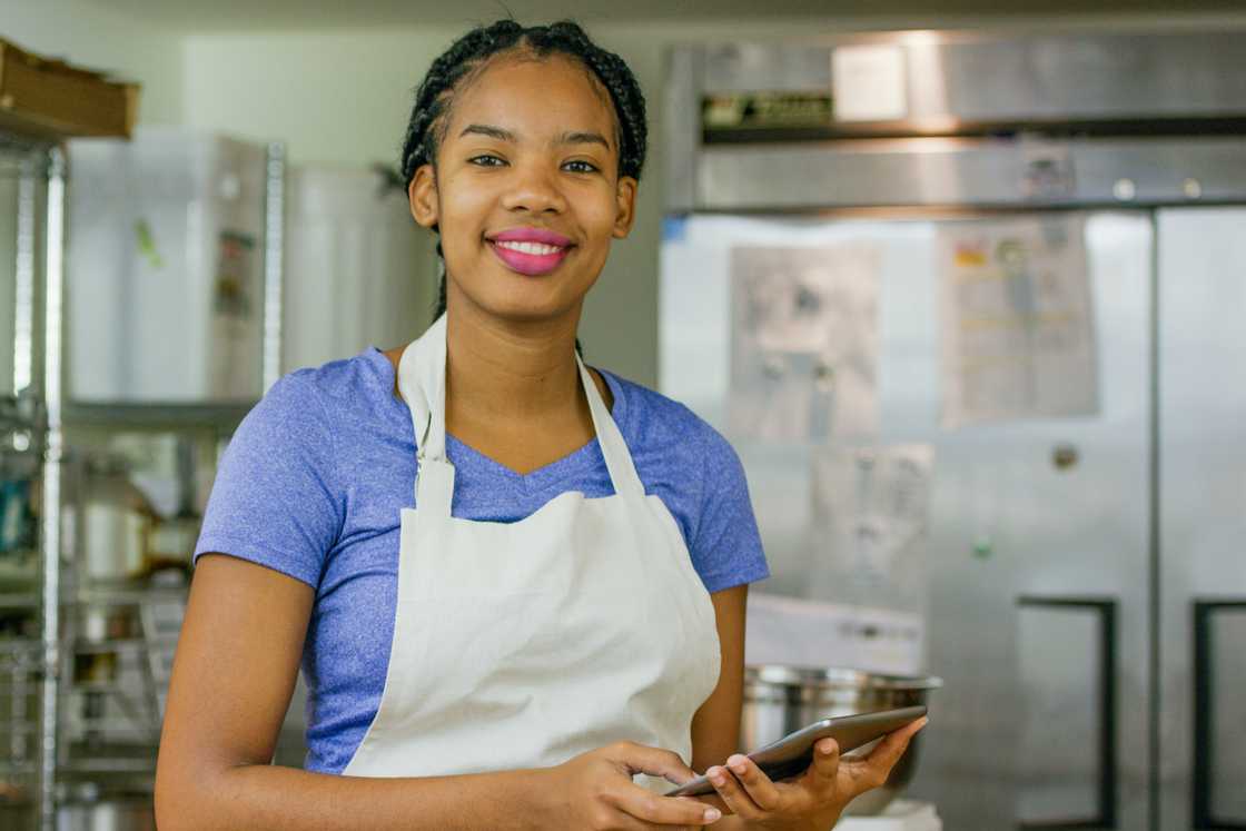 A young African American baker checks her sales A young African American baker checks her sales