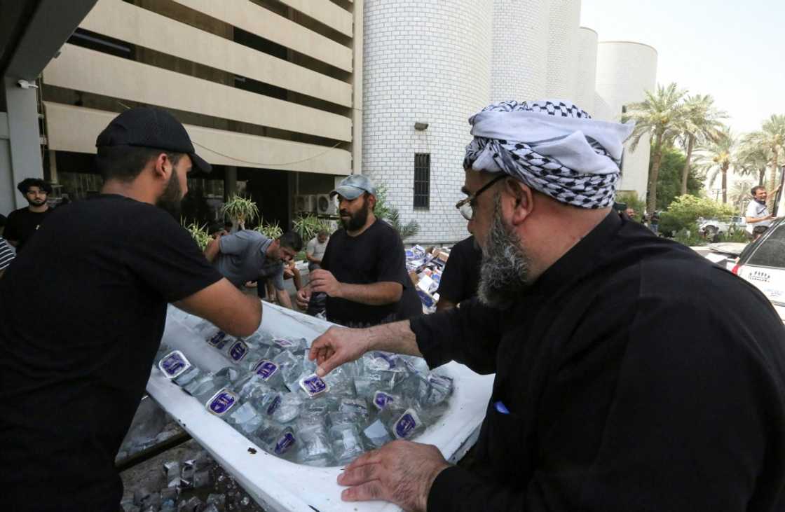 Supporters of Iraqi cleric Moqtada Sadr distribute water to fellow demonstrators, outside Iraq's parliament building on the second day of their occupation Supporters of Iraqi cleric Moqtada Sadr distribute water to fellow demonstrators, outside Iraq's parliament building on the second day of their occupation