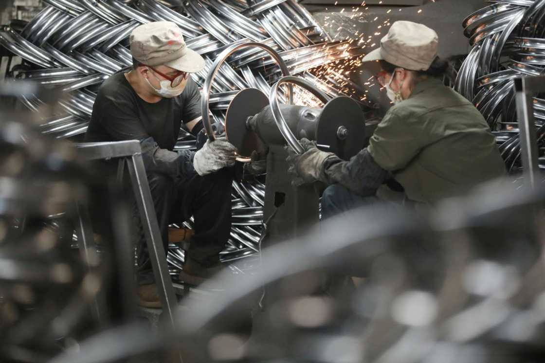 Workers produce bicycle parts at a factory in Hangzhou, China