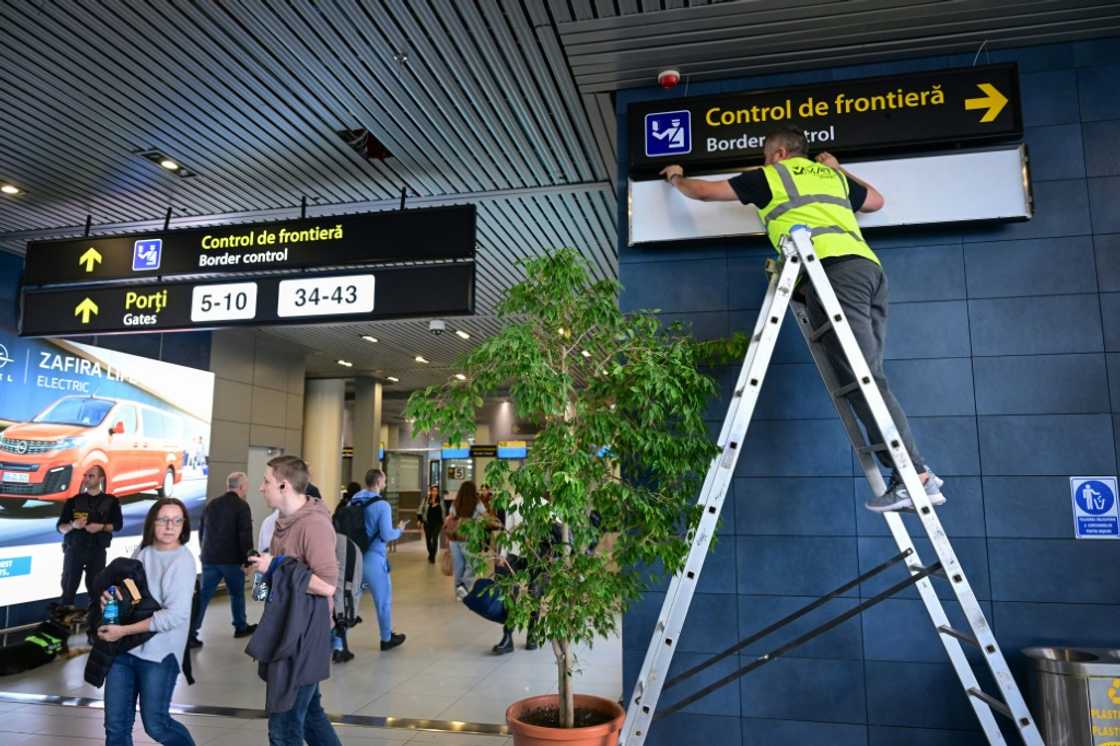 A Romanian worker changes the signs for passengers at Henri Coanda International Airport ahead of Romania and Bulgaria taking a first step into the Schengen visa free travel area on Sunday A Romanian worker changes the signs for passengers at Henri Coanda International Airport ahead of Romania and Bulgaria taking a first step into the Schengen visa free travel area on Sunday