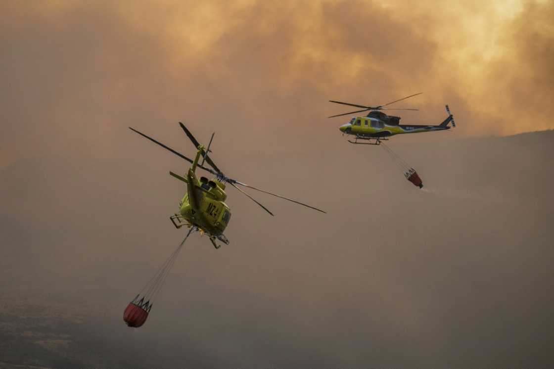 Two firefighter helicopters fly over blaze in a national park in northwestern Spain in late August, amid blistering summer heat. In October, Spain recorded the hottest temperatures for that month since records started in 1961 Two firefighter helicopters fly over blaze in a national park in northwestern Spain in late August, amid blistering summer heat. In October, Spain recorded the hottest temperatures for that month since records started in 1961