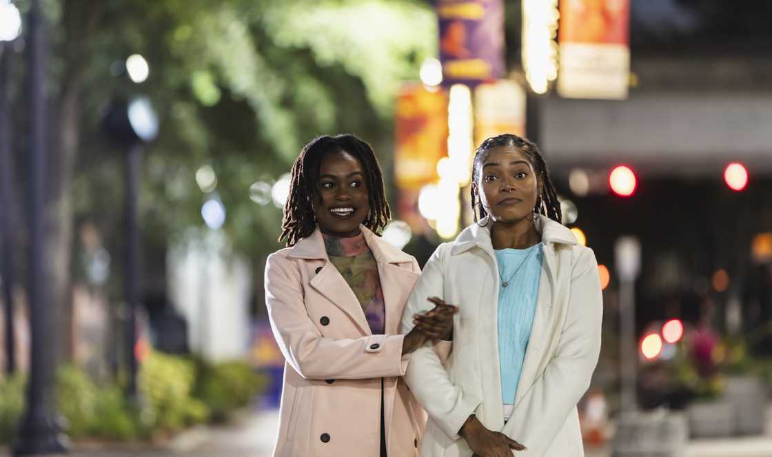Two women walking home at night, one frustrated while the other looks away.