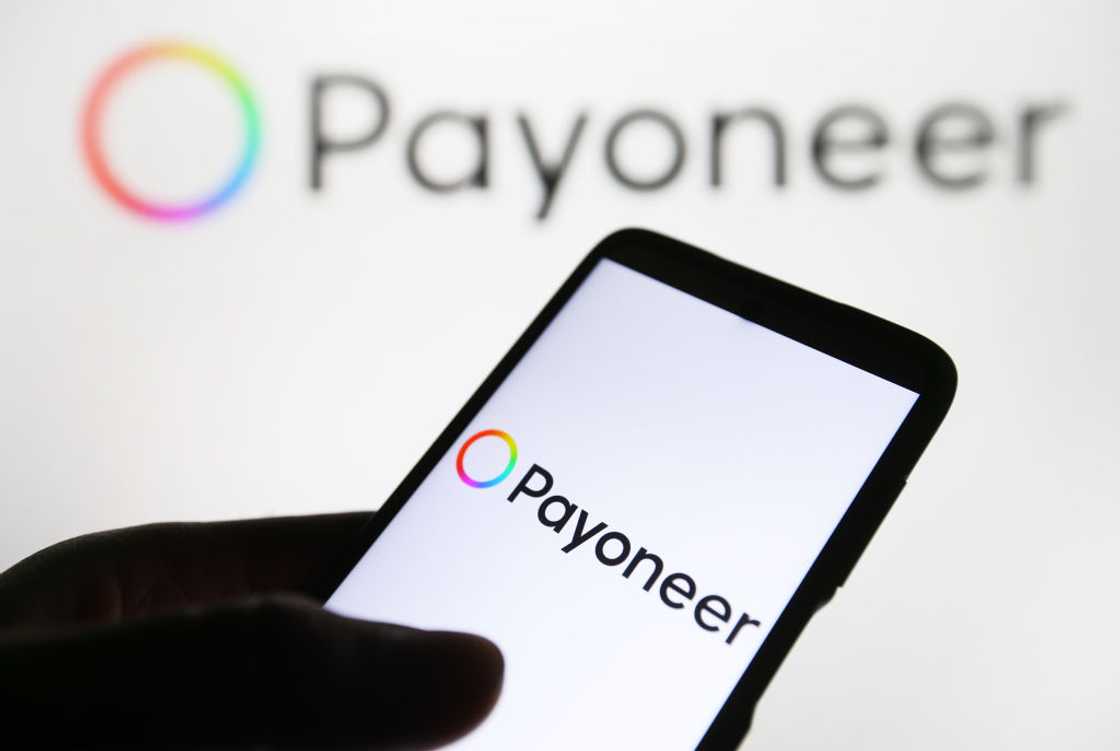 The Payoneer logo appears on a smartphone and a pc screen. The Payoneer logo appears on a smartphone and a pc screen.