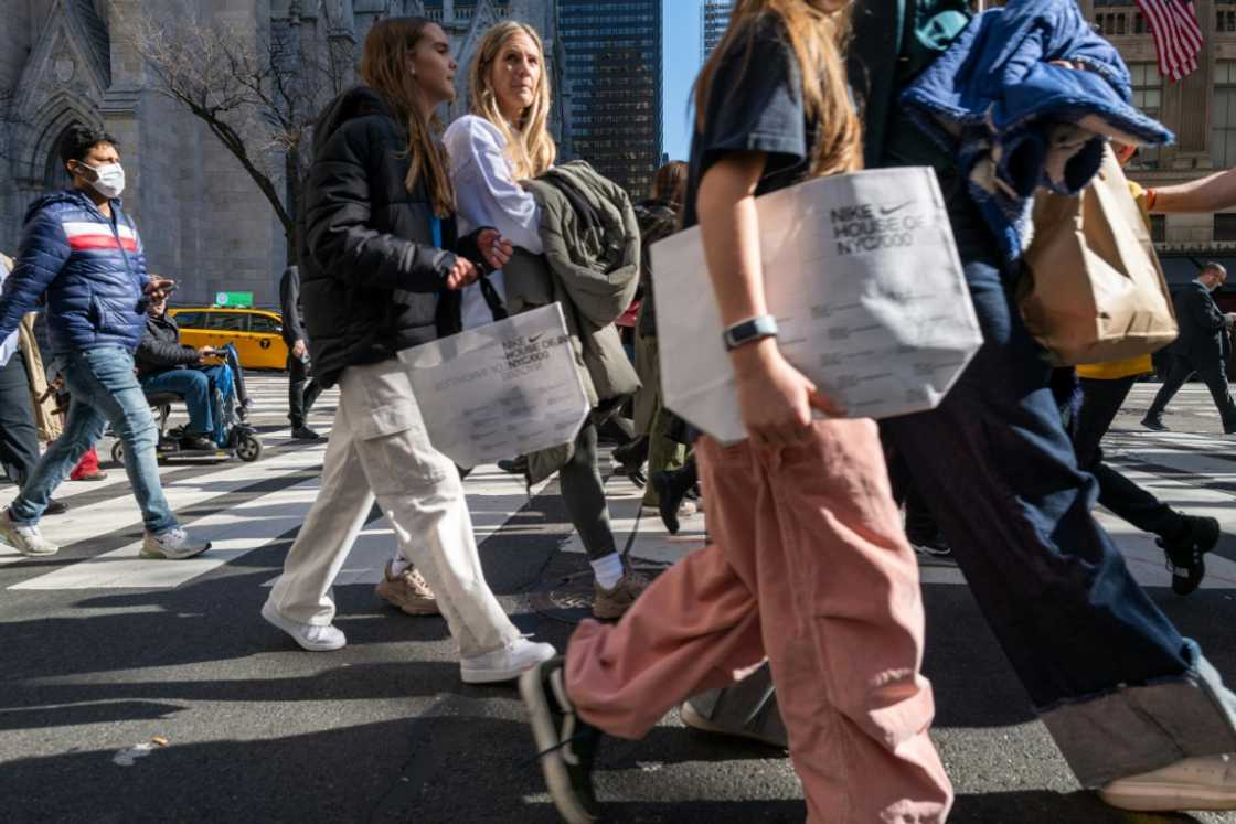 Pedestrians stroll along 5th Avenue in Manhattan, a premier shopping street in New York City
