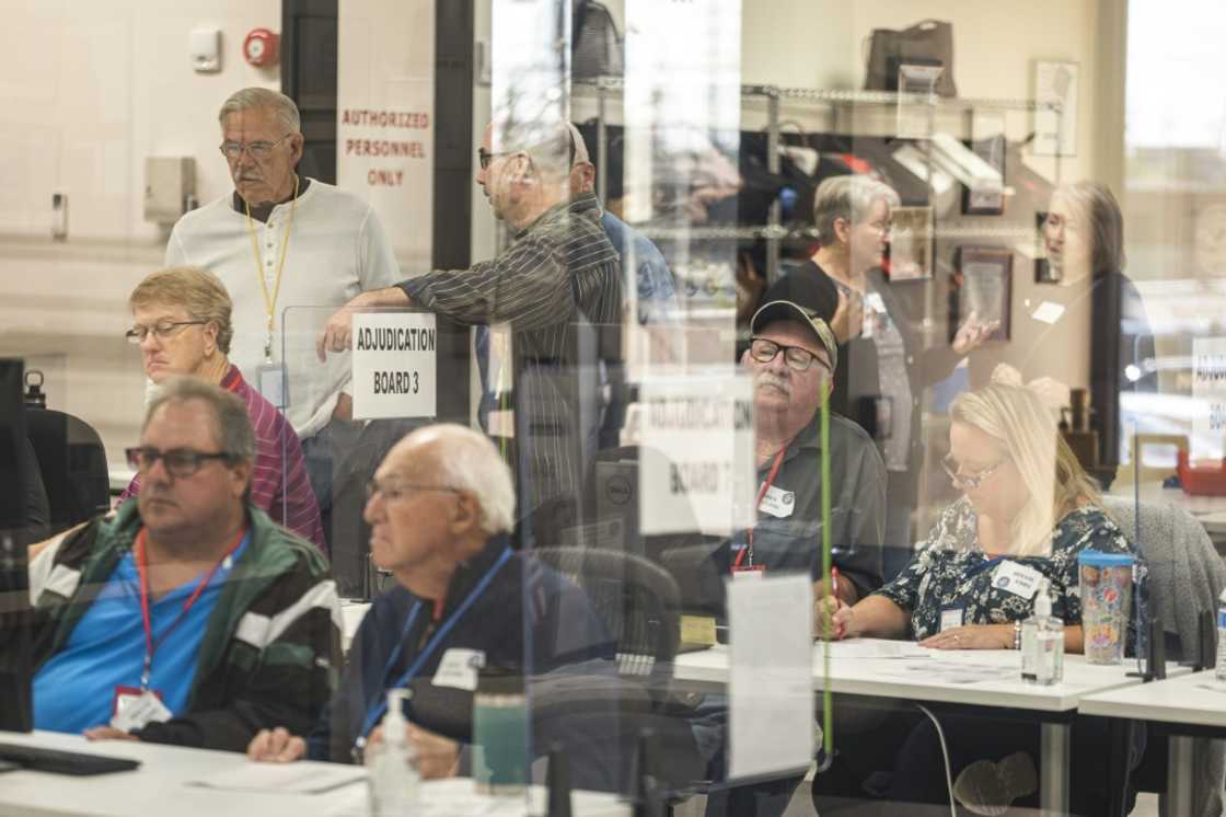 Poll workers handle ballots for the US midterm elections, in the presence of observers from both Democratic and Republican parties, at the Maricopa County Tabulation and Elections Center (MCTEC) in Phoenix, Arizona on October 25, 2022 Poll workers handle ballots for the US midterm elections, in the presence of observers from both Democratic and Republican parties, at the Maricopa County Tabulation and Elections Center (MCTEC) in Phoenix, Arizona on October 25, 2022