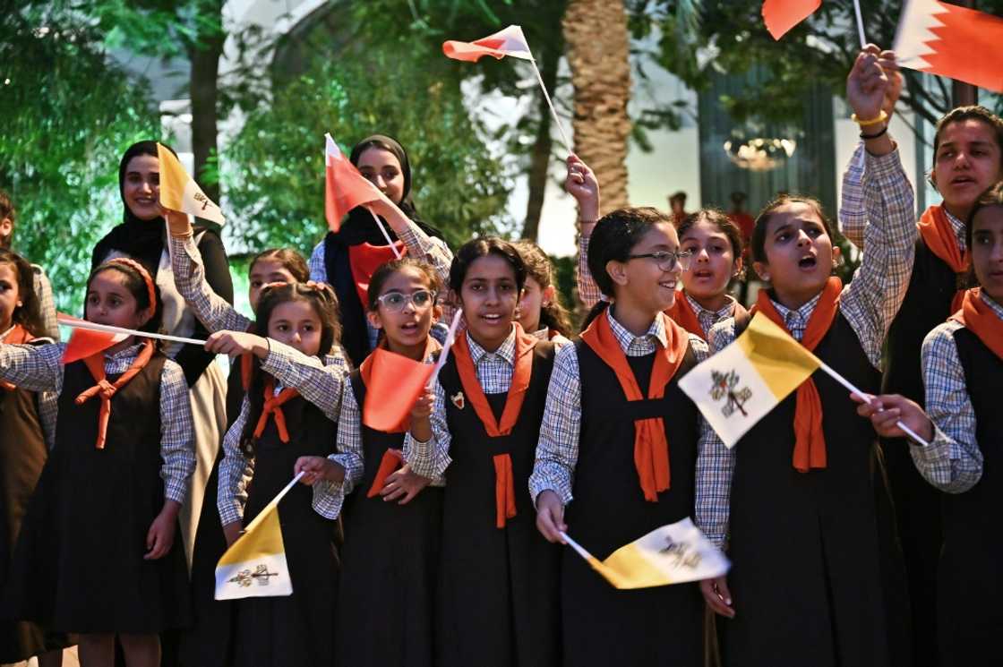 Children wave flags to welcome the pope outside the Royal Palace in Awali, south of the Bahraini capital Manama