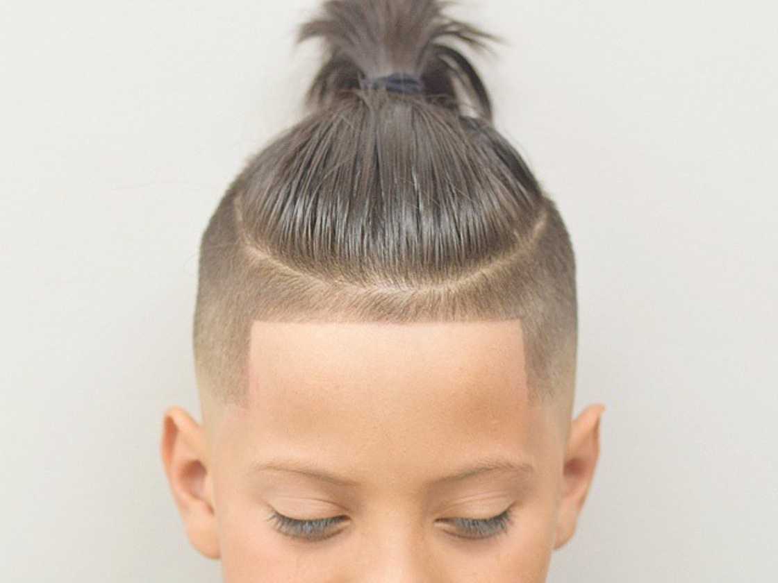 A cute little boy is rocking an undercut ponytail