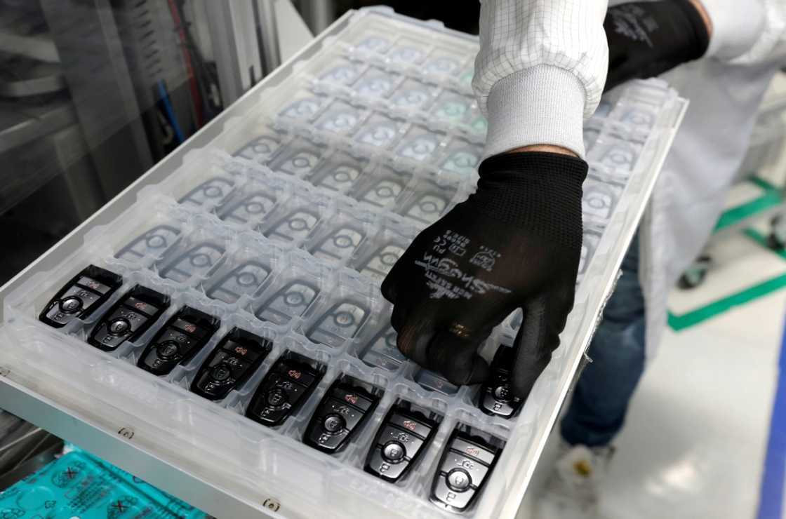 A worker assembles electronic car keys at a manufacturing plant in Mexico A worker assembles electronic car keys at a manufacturing plant in Mexico