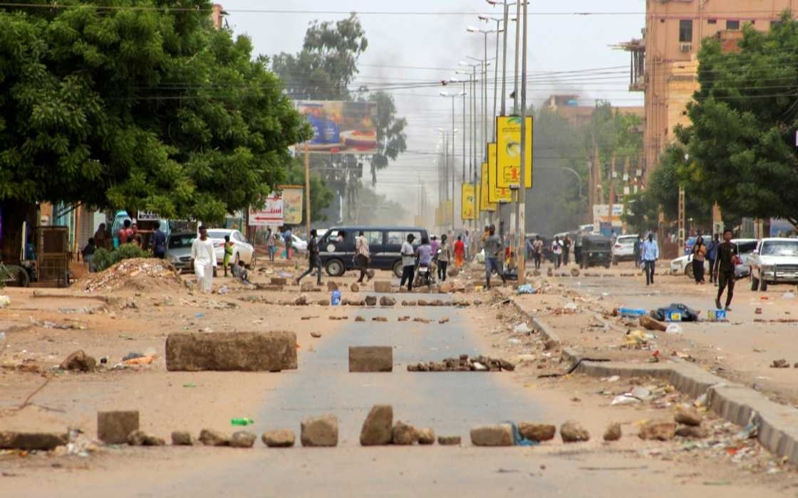 Smoke billows as Sudanese protesters take part in an anti-coup demonstration on a barricaded street in the Daym - Bashdar station area in central Khartoum, on July 17, 2022