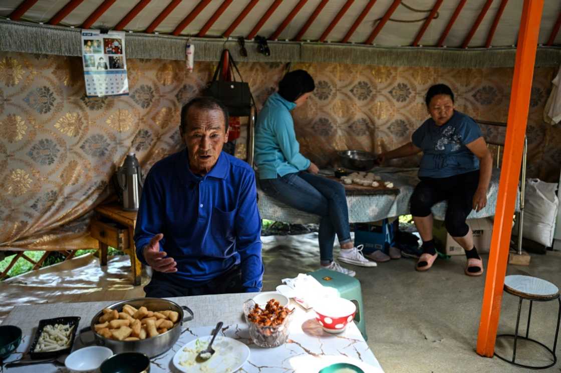 Bat-Ulzii Bat-Erdene (L), the father of financial consultant Bat-Erdene Khulan (C) who now lives in the capital Ulaanbaatar, talks while his wife Sanduijav Altakhuyag (R) prepares lunch with their daughter inside a ger in Batsumber in Tuv province Bat-Ulzii Bat-Erdene (L), the father of financial consultant Bat-Erdene Khulan (C) who now lives in the capital Ulaanbaatar, talks while his wife Sanduijav Altakhuyag (R) prepares lunch with their daughter inside a ger in Batsumber in Tuv province