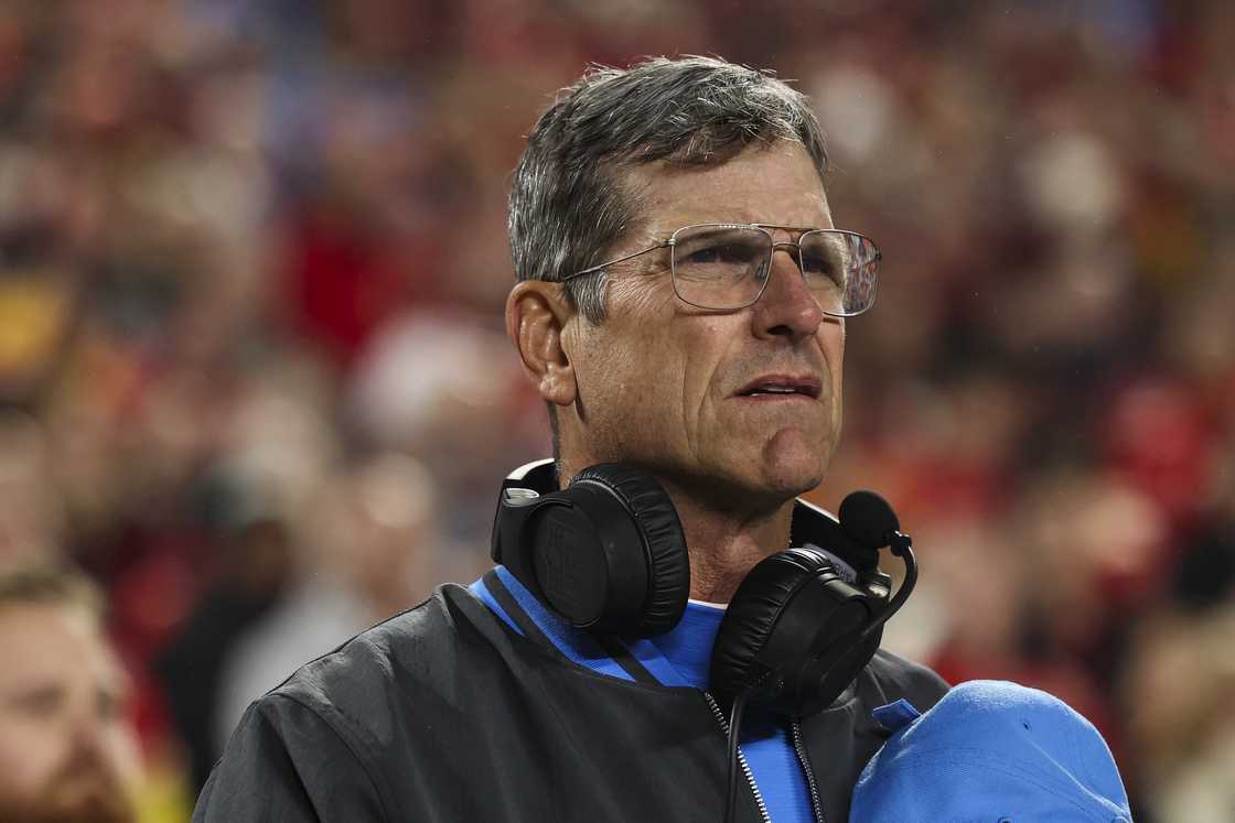 Jim Harbaugh looks on from the sideline during the national anthem before an NFL football game