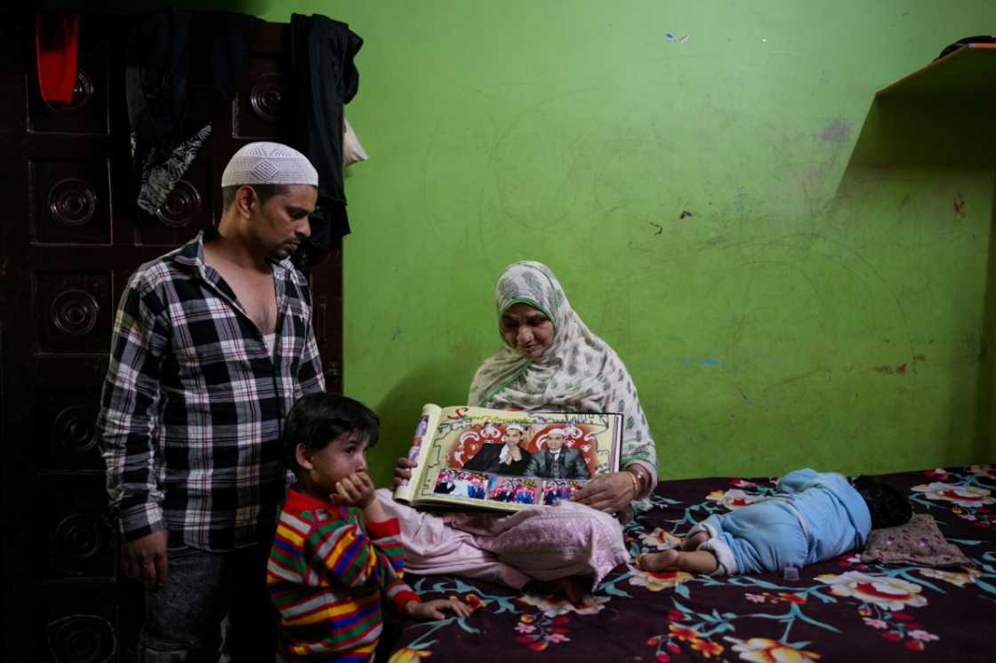 The mother of Faheem Qureshi, who was killed in anti-Muslim riots in February, sits with a picture of her son The mother of Faheem Qureshi, who was killed in anti-Muslim riots in February, sits with a picture of her son