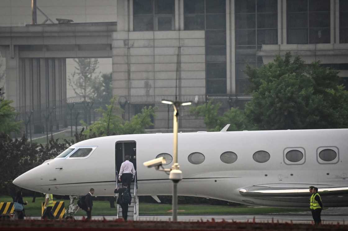 Tesla chief Elon Musk (in white) boards his private jet before departing Beijing Capital International Airport on May 31 Tesla chief Elon Musk (in white) boards his private jet before departing Beijing Capital International Airport on May 31