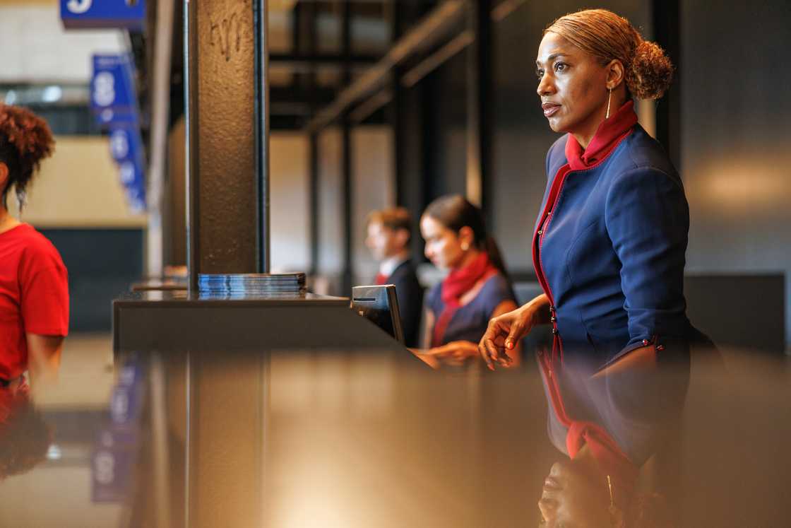 An airline agent stands shocked after hearing tragic flight news. An airline agent stands shocked after hearing tragic flight news.