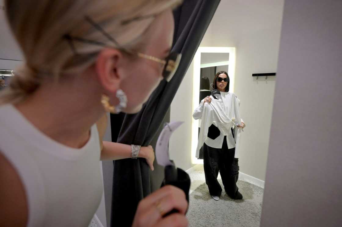 A woman tries on clothes in a fitting room at a shopping centre in Moscow A woman tries on clothes in a fitting room at a shopping centre in Moscow