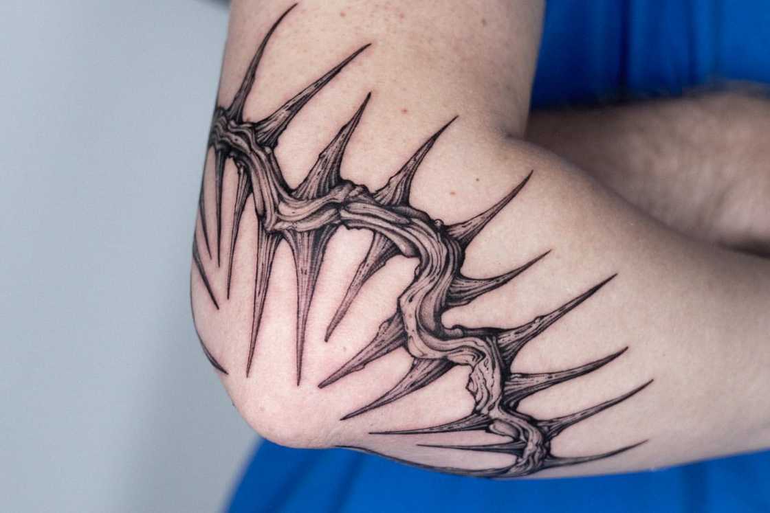 A black and grey crown of sharp thorns elbow tattoo A black and grey crown of sharp thorns elbow tattoo
