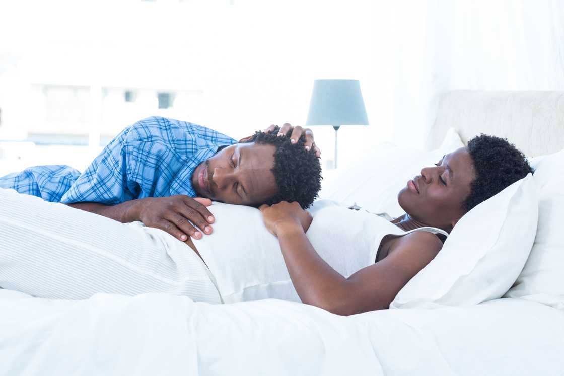 An expectant couple talks in bed An expectant couple talks in bed