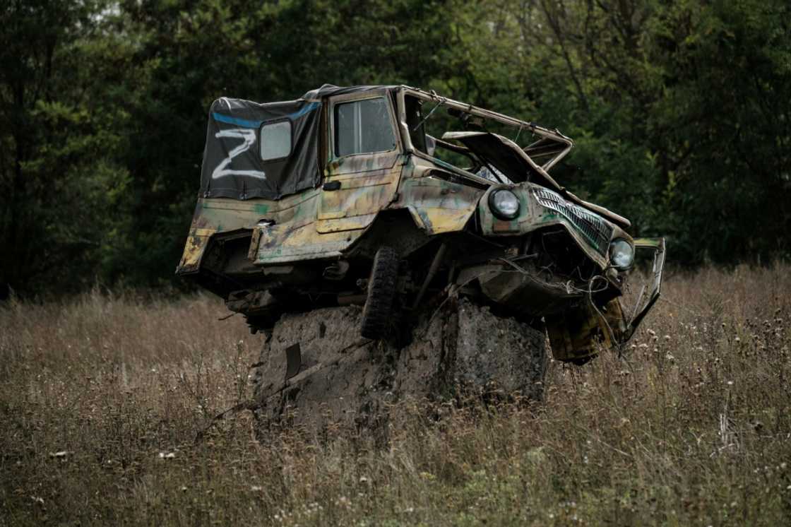 A damaged car bearing the letter 'Z', the symbol of Russian forces, sits at a possible mine field near a suspected mass grave in Kozacha Lopan A damaged car bearing the letter 'Z', the symbol of Russian forces, sits at a possible mine field near a suspected mass grave in Kozacha Lopan