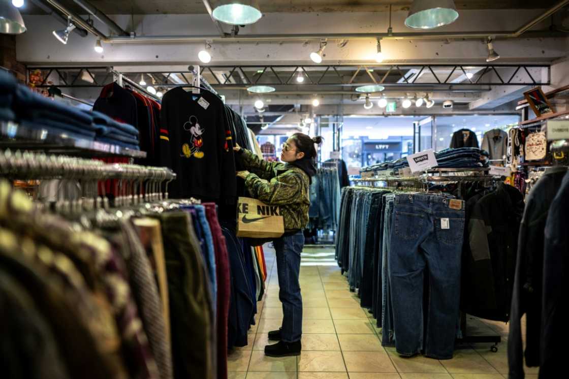 A customer visits a secondhand clothes shop in the Harajuku district of Tokyo A customer visits a secondhand clothes shop in the Harajuku district of Tokyo