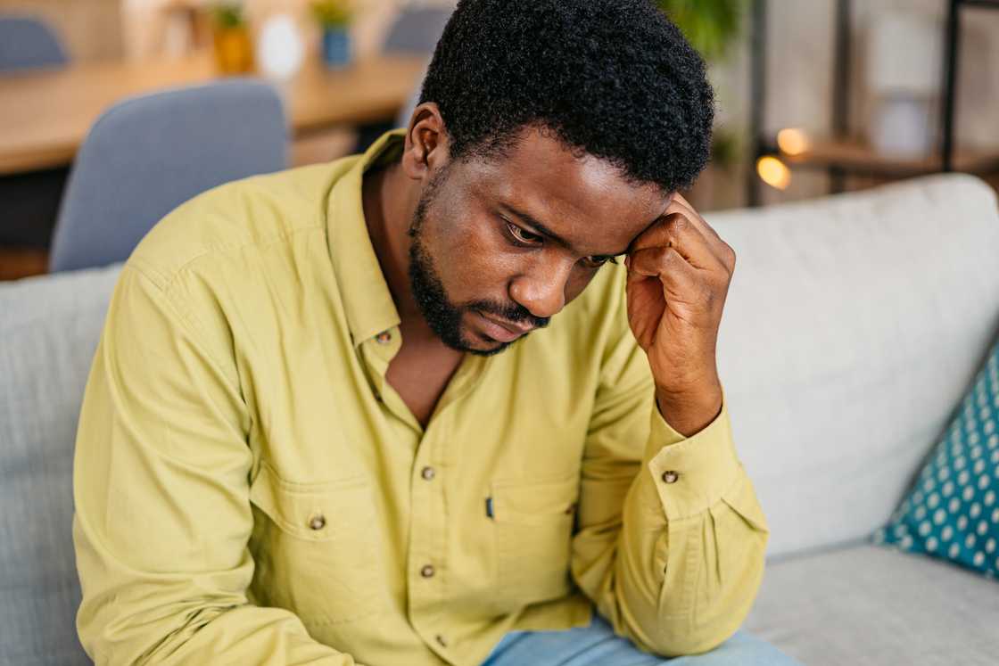 A sad man sitting on the sofa at home and sulking. A sad man sitting on the sofa at home and sulking.