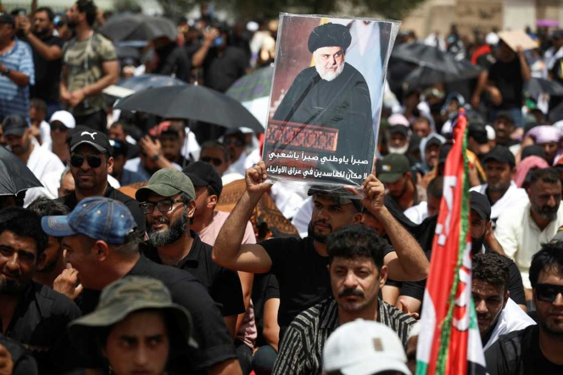 Supporters of Iraqi Shiite cleric Moqtada Sadr carry his portrait following Friday prayers outside the parliament building Supporters of Iraqi Shiite cleric Moqtada Sadr carry his portrait following Friday prayers outside the parliament building
