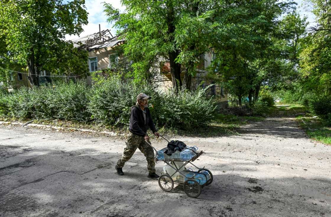 Sergiy Medvedev pushes water containers through the streets of Siversk in Ukraine's Donetsk region Sergiy Medvedev pushes water containers through the streets of Siversk in Ukraine's Donetsk region