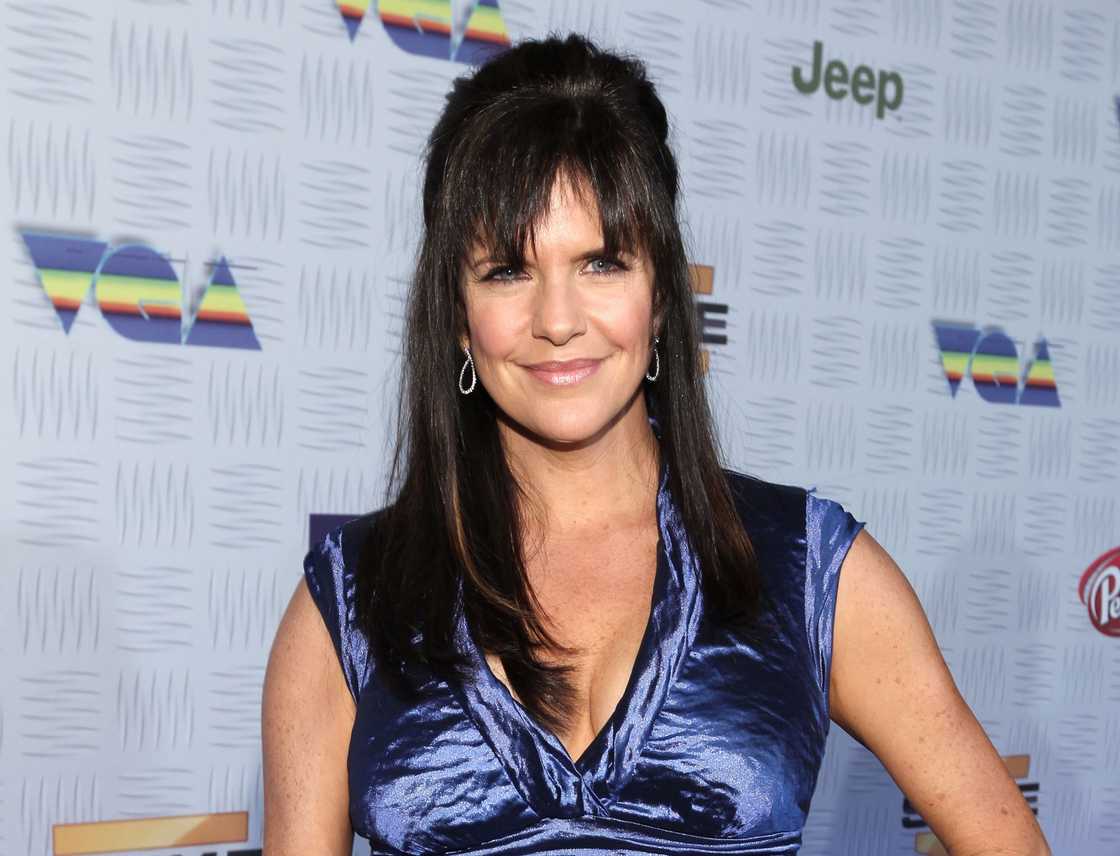 Jennifer Hale wearing a blue dress and smiling at the camera.