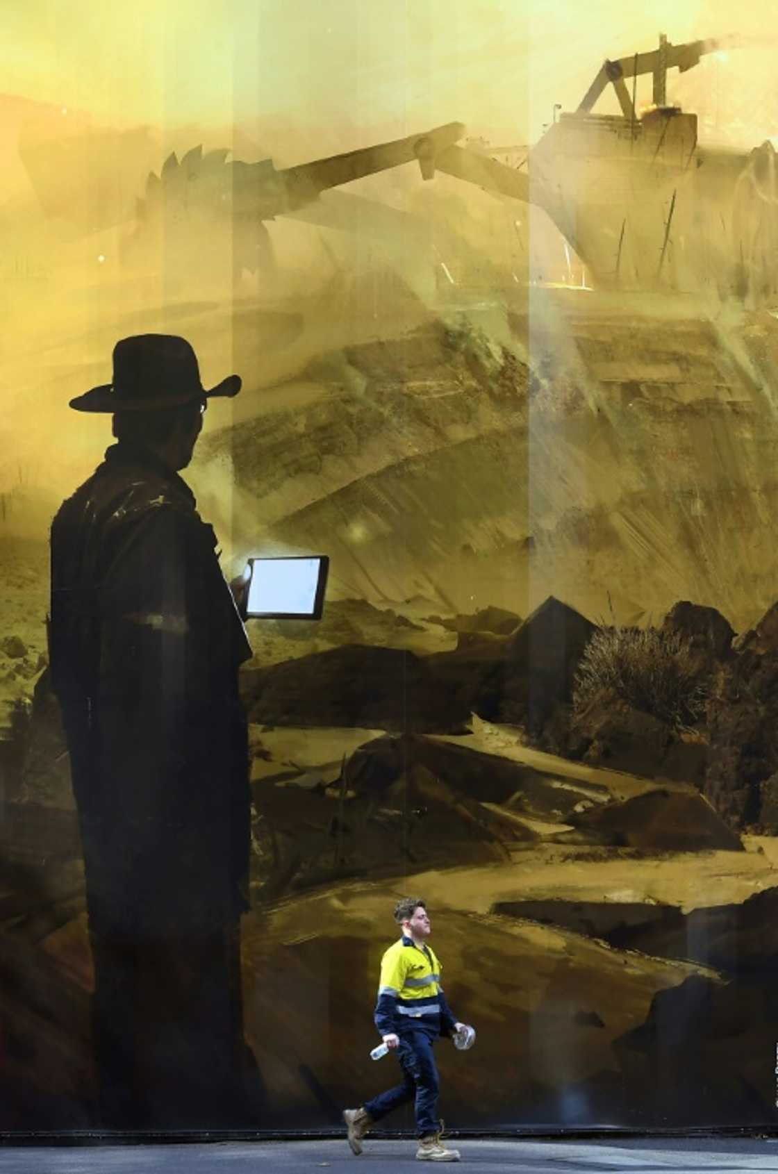 A man walks past a mural of a mine by artist Simon Denny in Melbourne A man walks past a mural of a mine by artist Simon Denny in Melbourne