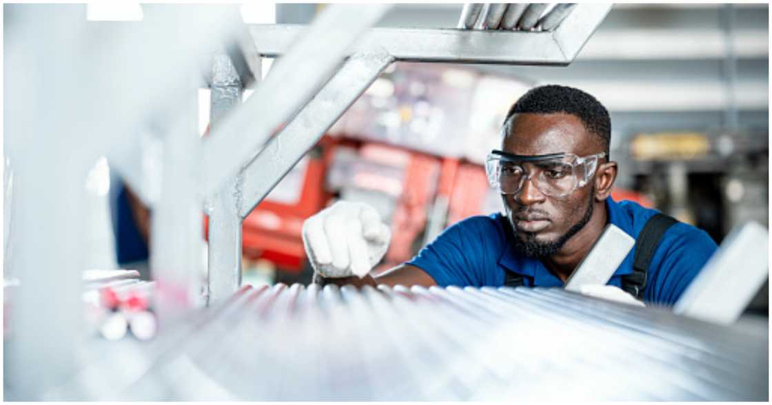 A man inspects a steel pipe in production A man inspects a steel pipe in production