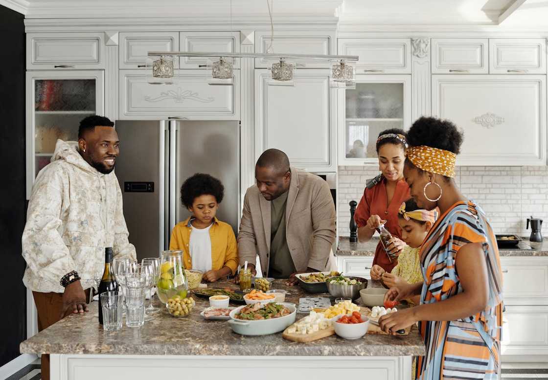 A family prepares food together in a bright kitchen. A family prepares food together in a bright kitchen.