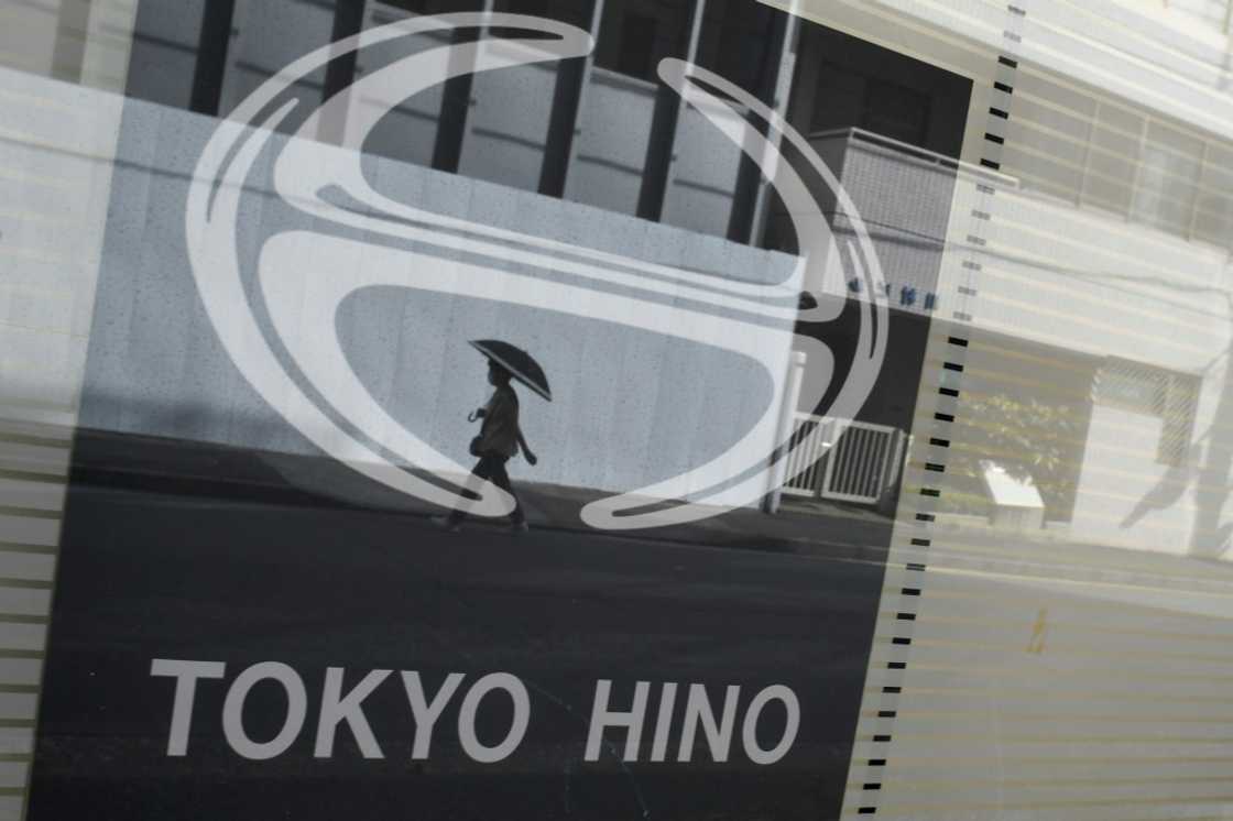 This photo taken in Tokyo in August 2022 shows the logo Japanese truck-maker Hino Motors, a arm of Toyota, reflected in glass