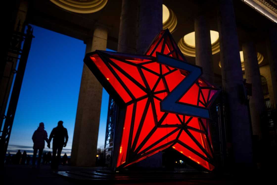 Pedestrians walk past a New Year decoration stylised as the 'Kremlin Star,' bearing a Z letter, a tactical insignia of Russian troops in Ukraine Pedestrians walk past a New Year decoration stylised as the 'Kremlin Star,' bearing a Z letter, a tactical insignia of Russian troops in Ukraine